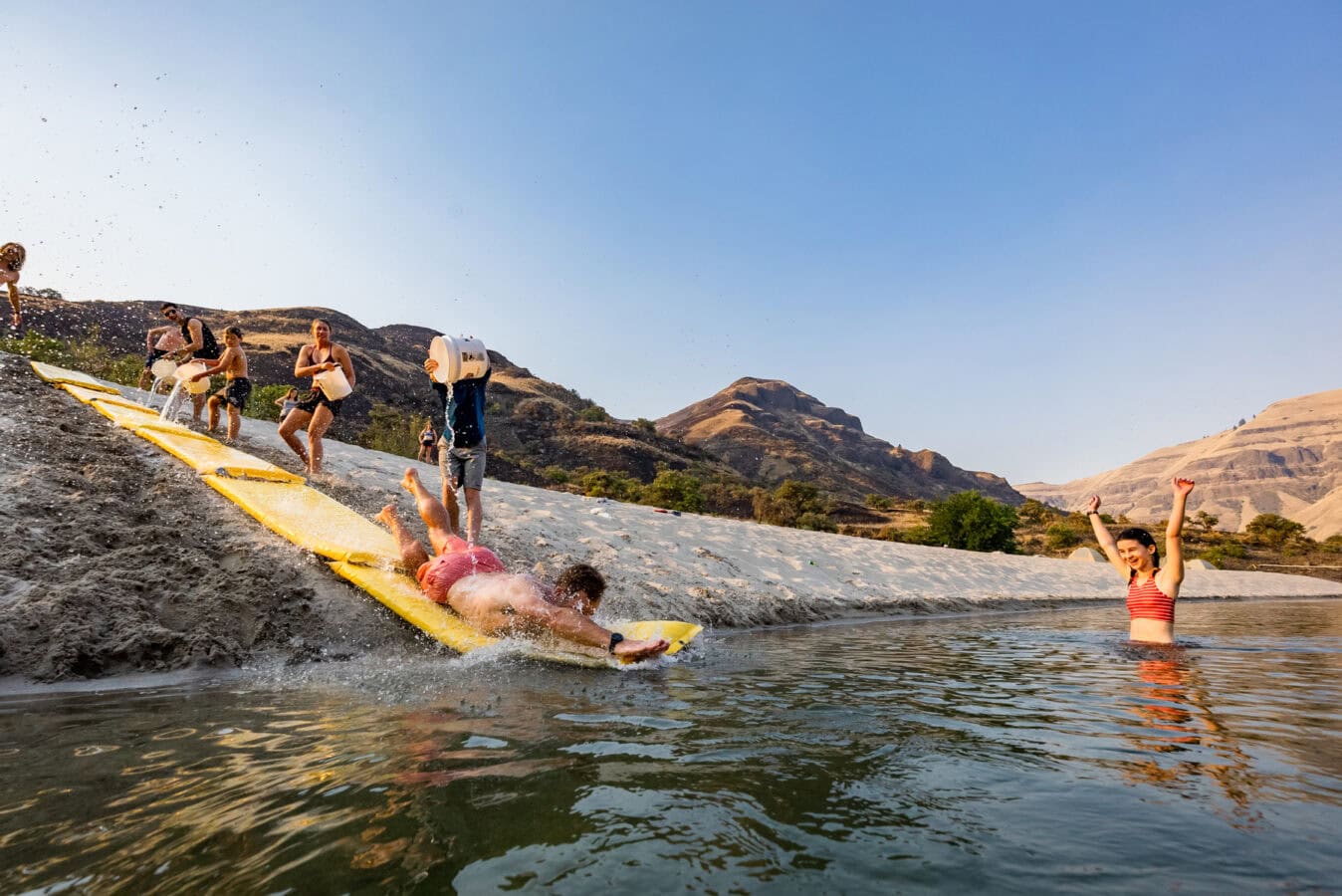 A man slides headfirst on a makeshift Slip 'n Slide into the Lower Salmon River
