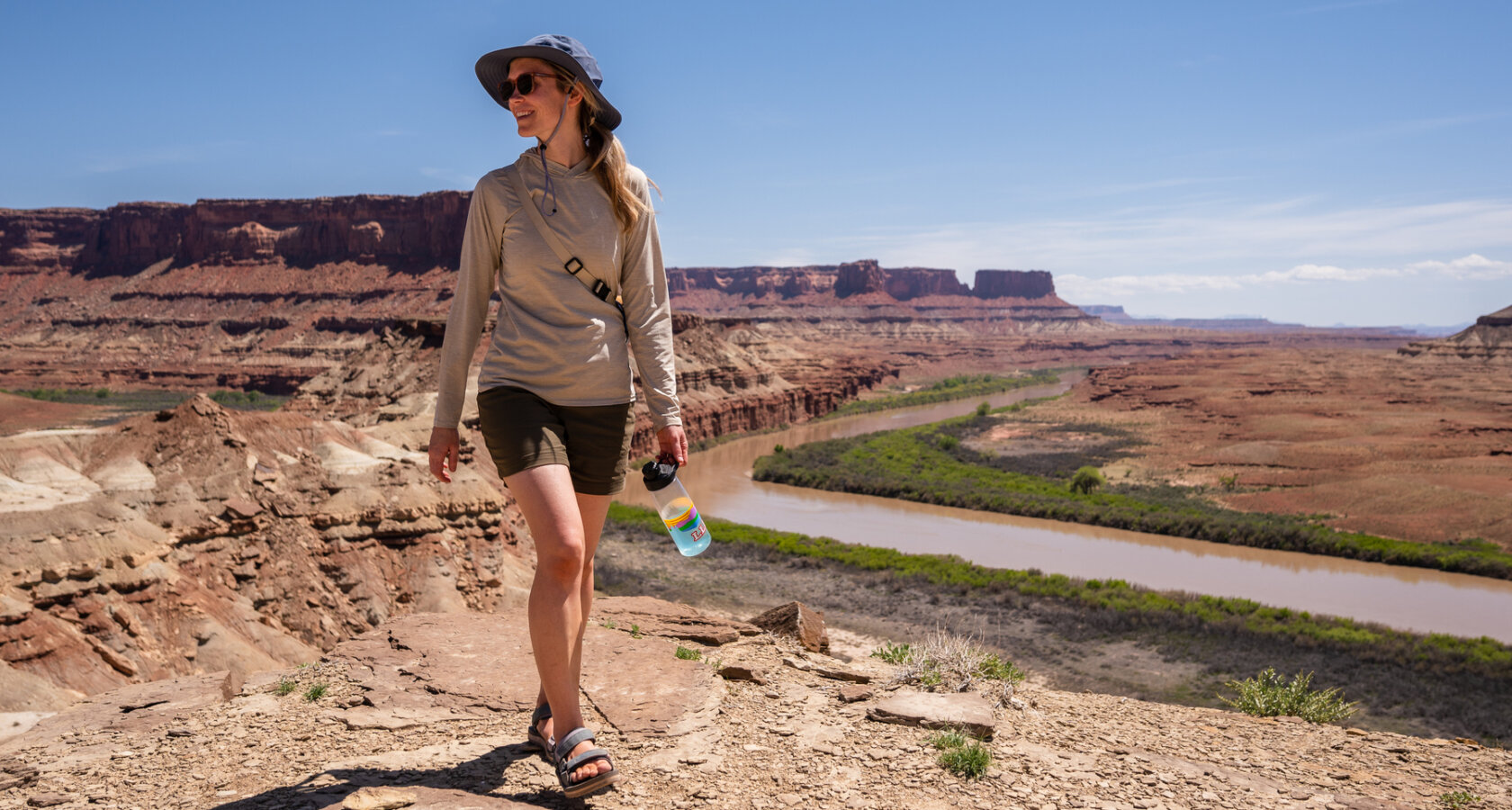 A woman walks above the Colorado River during a rafting trip with OARS in 2023