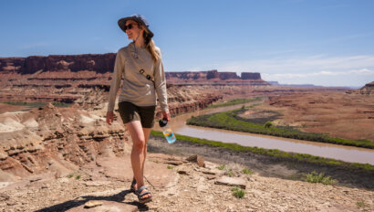 A woman walks above the Colorado River during a rafting trip with OARS in 2023
