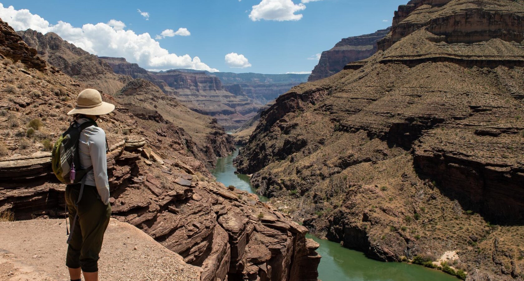 A woman stands on an overlook of the Colorado River in Grand Canyon.
