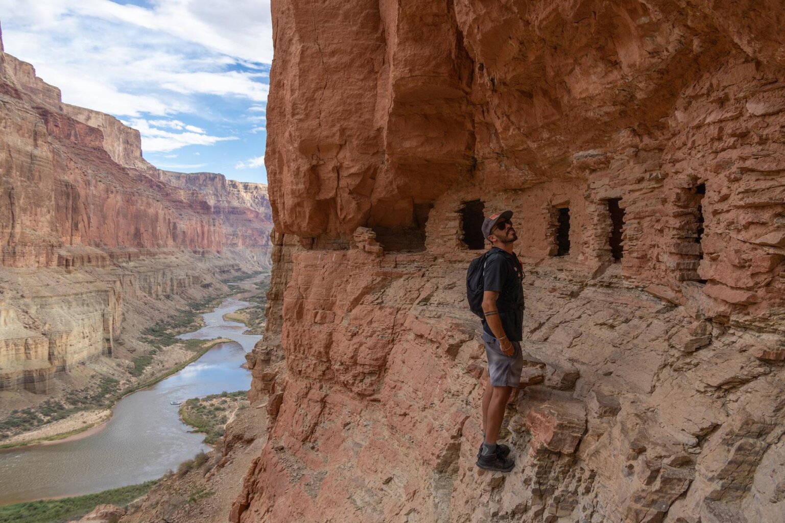 A man looking at the Nankoweap Granaries in Grand Canyon