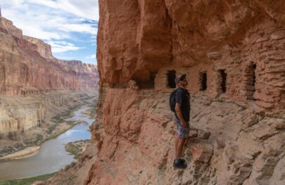A man looking at the Nankoweap Granaries in Grand Canyon