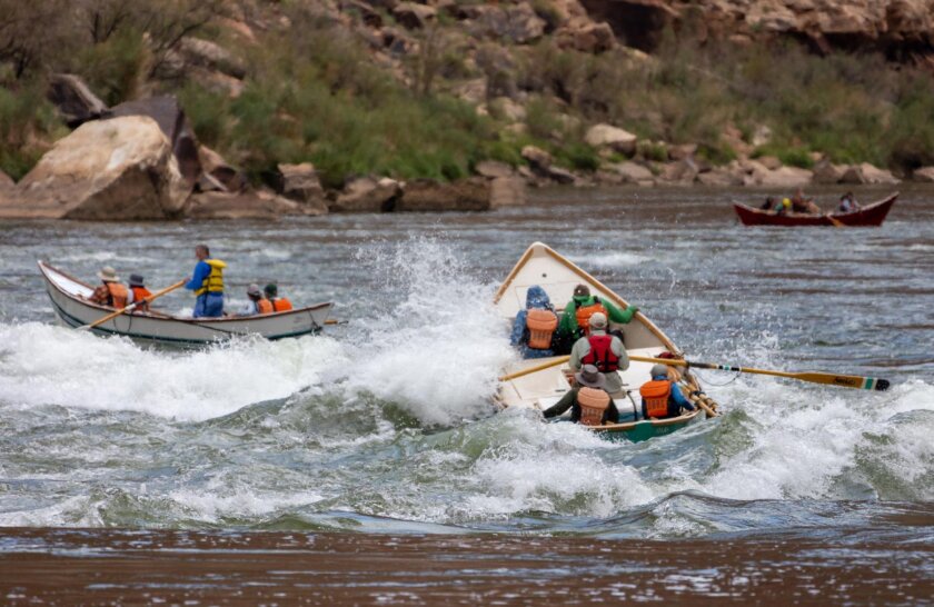 A dory splashes through a rapid on the Colorado River in Grand Canyon