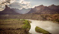 Landscape view of Desolation Canyon on the Green River with sun rays shining through clouds.