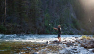 A man fly fishes from a rock at the edge of the Middle Fork of the Salmon River.