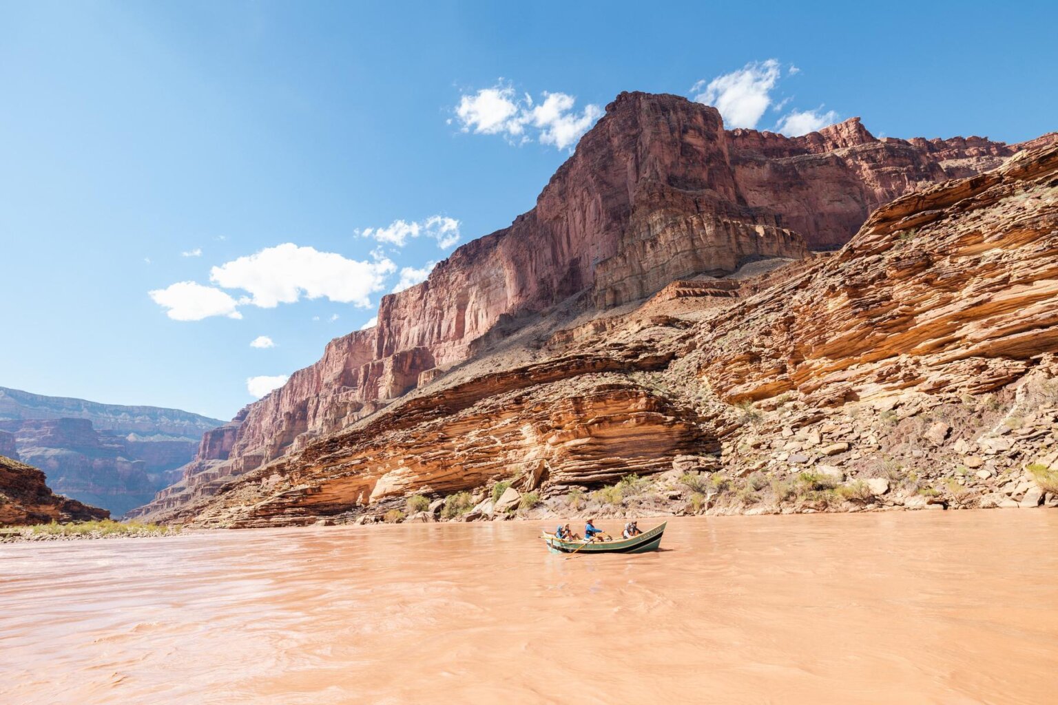 A dory drifts through Grand Canyon on a sunny day.