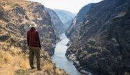 A hiker stands at a vista overlooking the Lower Salmon River and takes in the view.