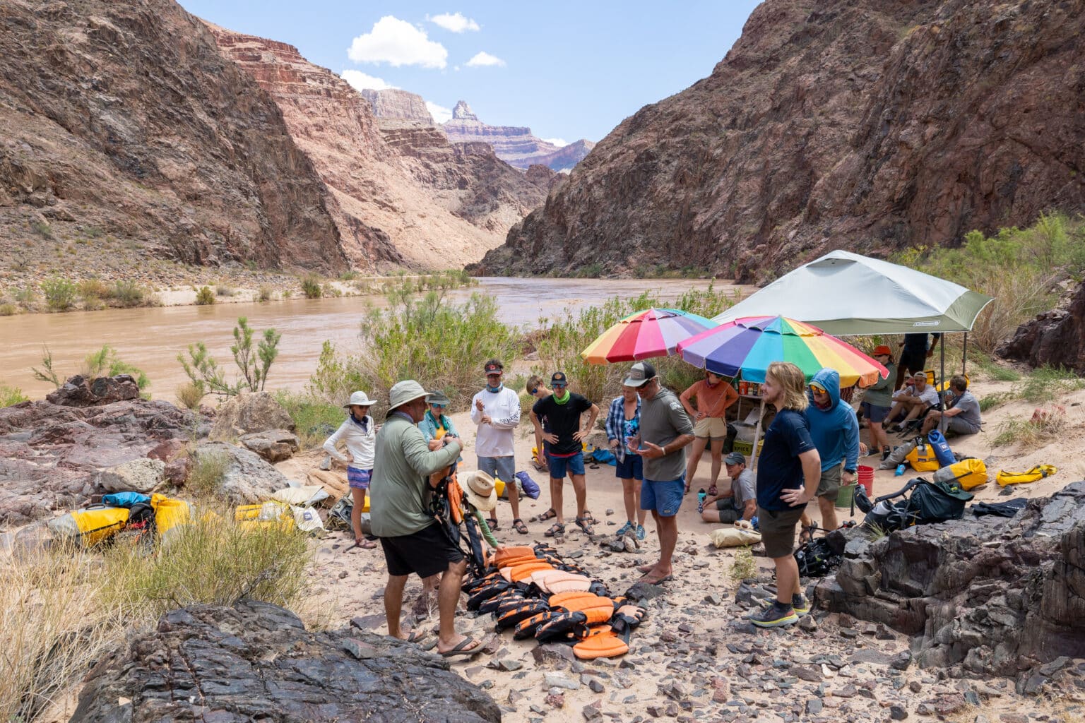 People gathered in front of the river with water safety gear.