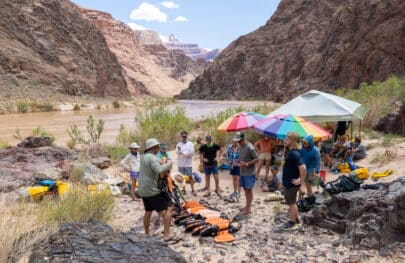 People gathered in front of the river with water safety gear.