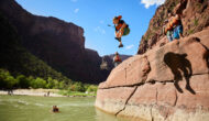 Kid jumping into a river from a rock.