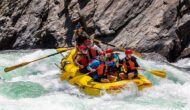 A group of rafters paddling through a rapid on the Tuolumne River.