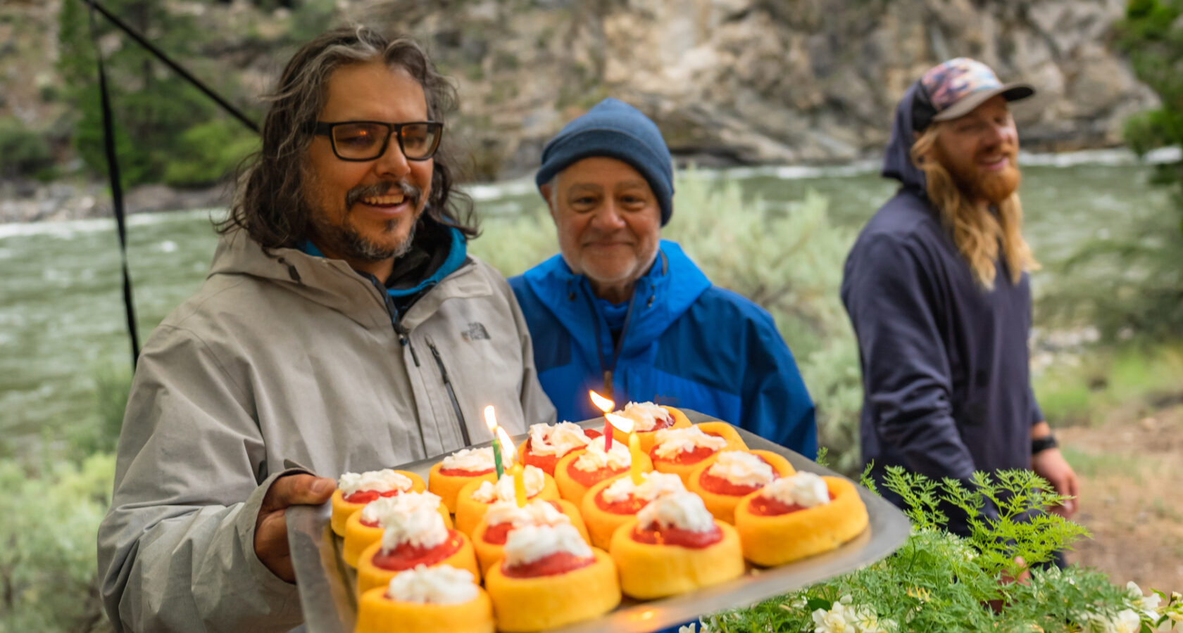 A man shows off a pound cake dessert with strawberry rhubarb sauce and whip cream