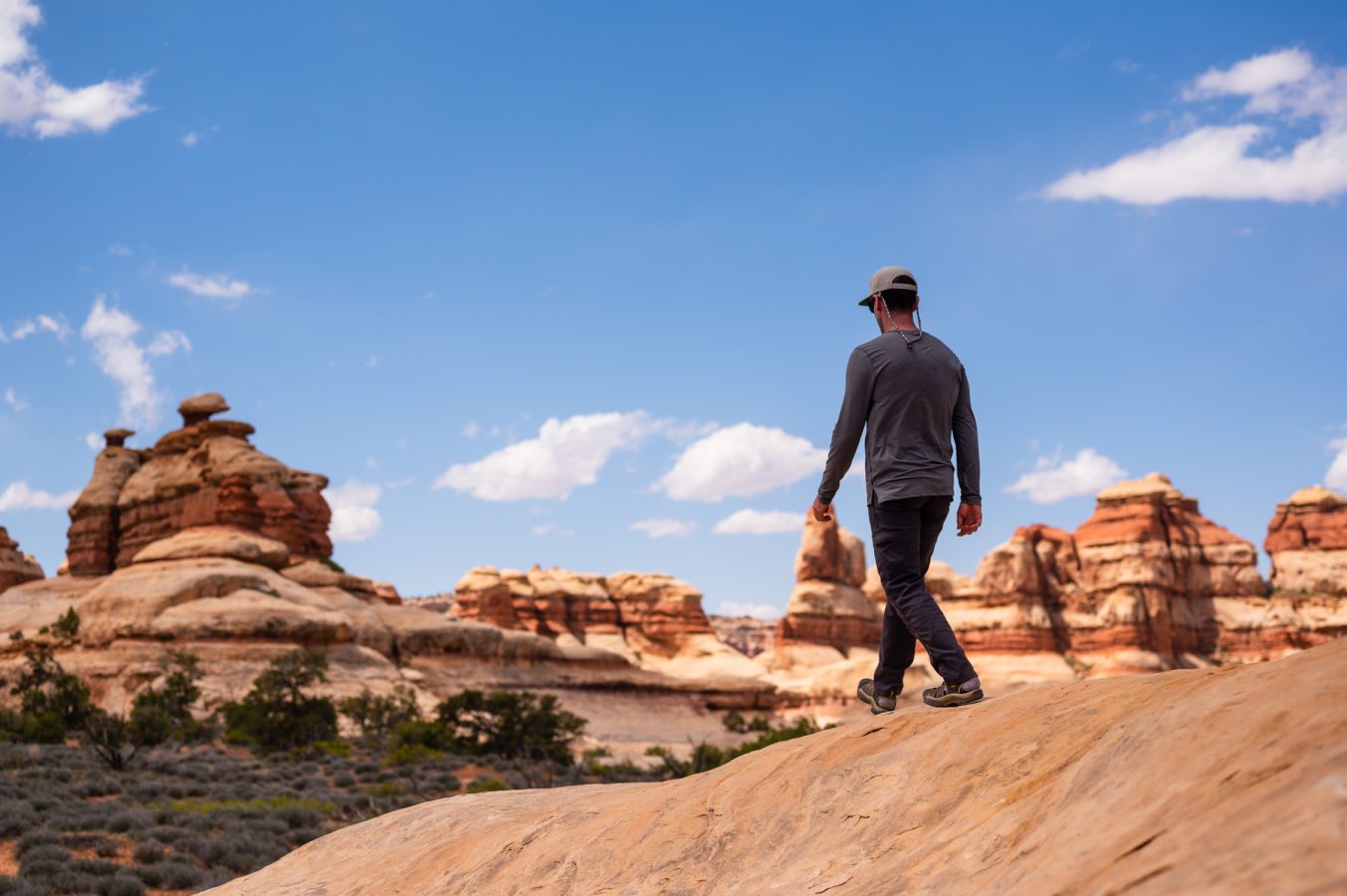 A man walking near The Dollhouse in Canyonlands National Park on an OARS hking trip