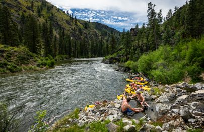Two guys soak in a hot spring on the edge of the Middle Fork Salmon River in Idaho
