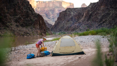 A woman sets up her campsite along the Colorado River in Grand Canyon