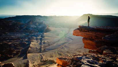 A person standing on a cliff overlooking Chile's vast Atacama Desert