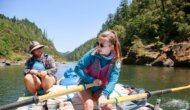 A student rows an oar raft down the Rogue River as an instructor watches.