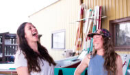Two women laughing in an airy boathouse setting