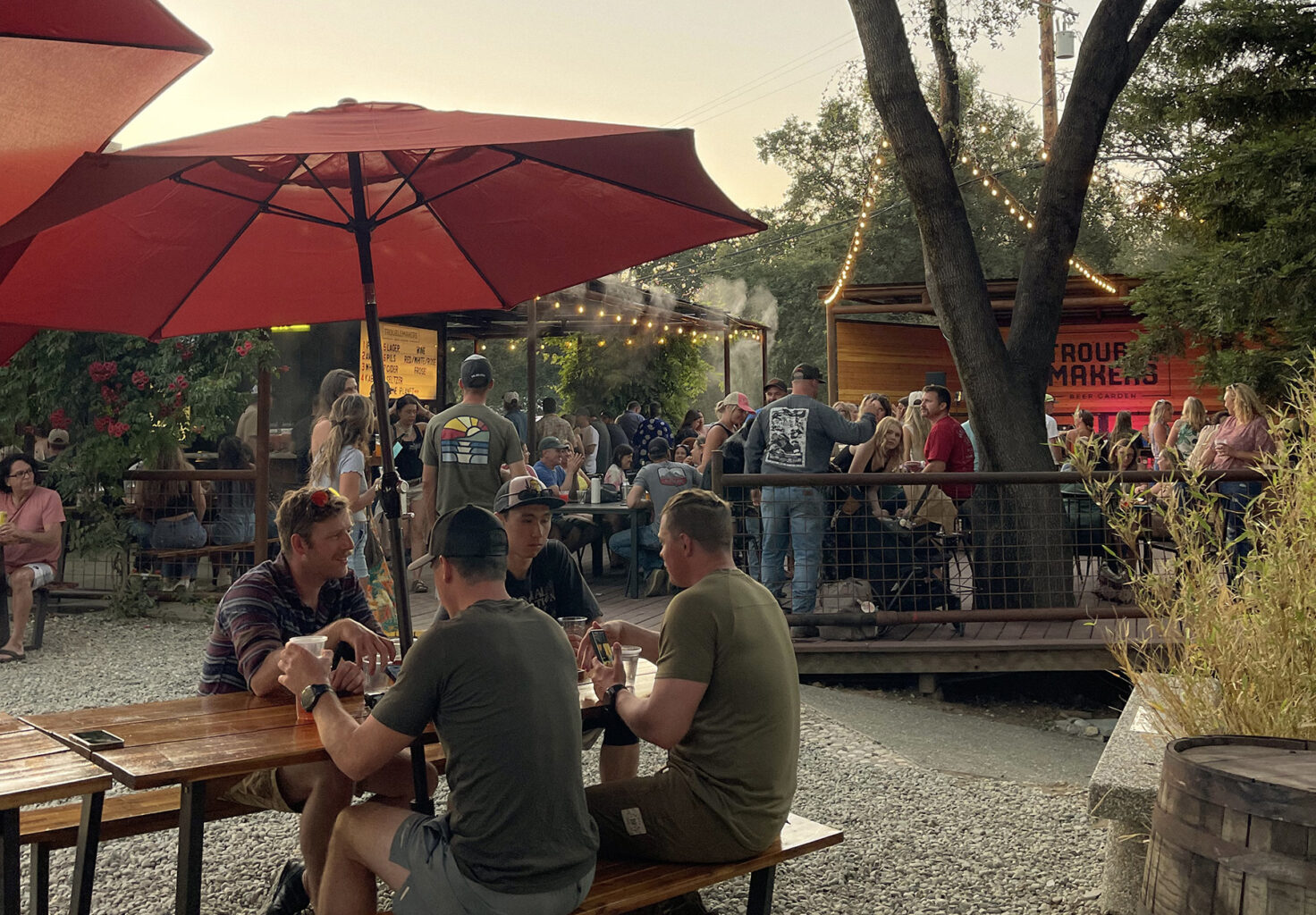 Outdoor beer garden and restaurant crowded with people.
