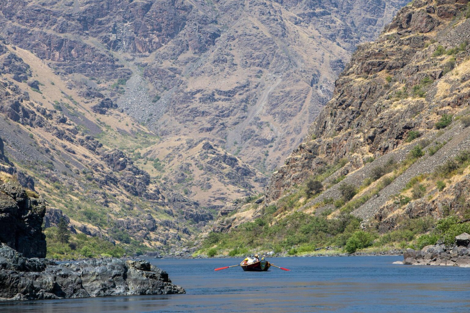 A dory rows down a scenic section of the Snake River in Hells Canyon, Idaho