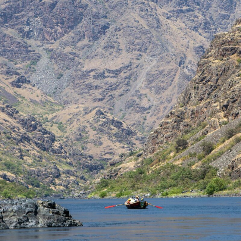 A dory rows down a scenic section of the Snake River in Hells Canyon, Idaho