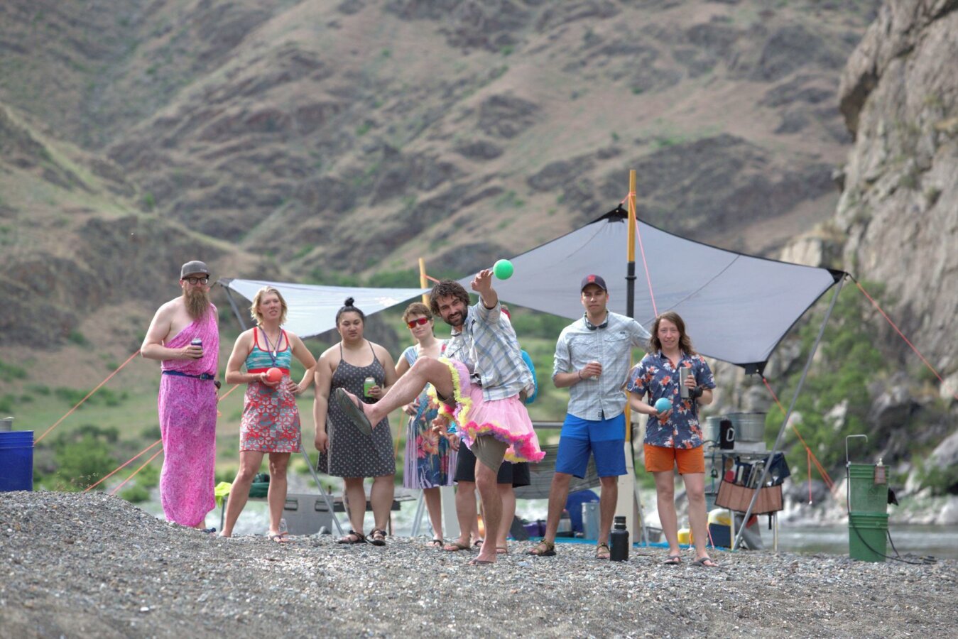 A group of people in costumes play bocce on the beach along the Snake River