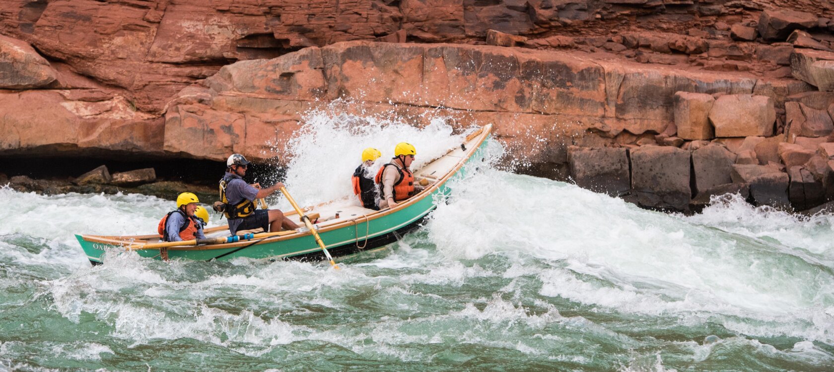 A dory boat goes through a rapid on the Colorado River through Grand Canyon.