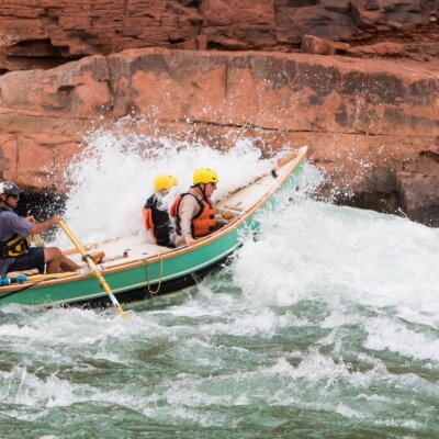 A dory boat goes through a rapid on the Colorado River through Grand Canyon.