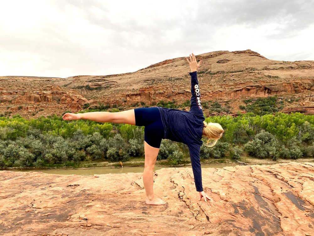 A woman strikes a yoga pose along the river.