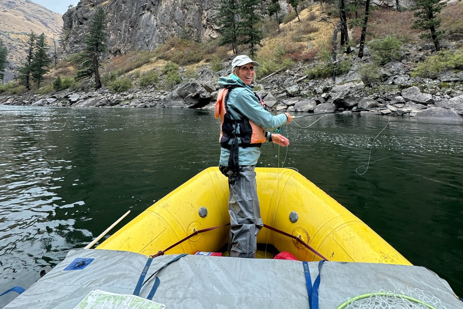 A woman fishes from the front of an OARS raft during a fishing trip on the Middle Fork of the Salmon River.