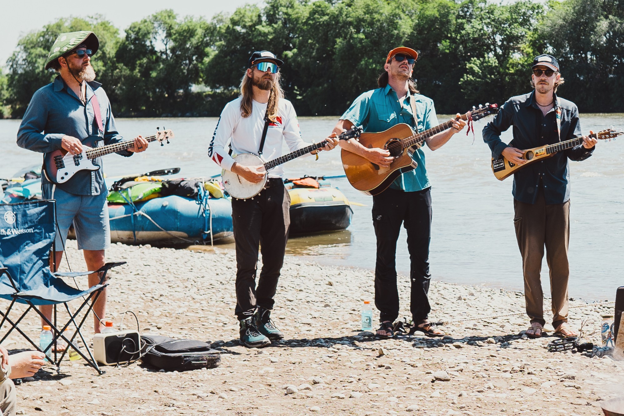 Members of A Brother's Fountain perform on a beach along the river in Idaho.