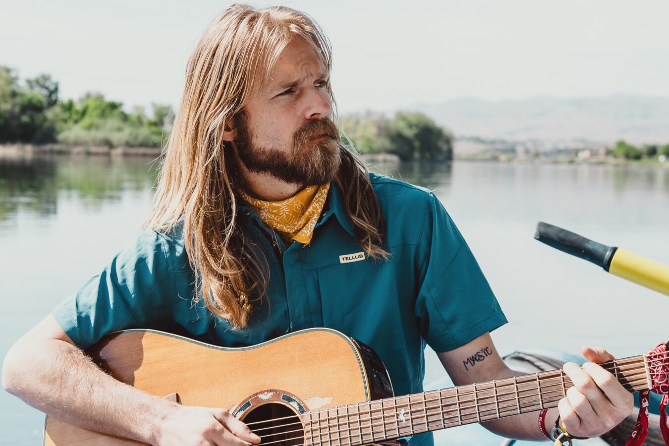 Graham Good of A Brother's Fountain plays his accoustic guitar on the river in Idaho.