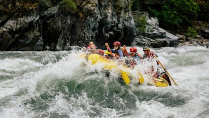 A yellow paddle raft splashes through a big wave on the Snake River in Hells Canyon