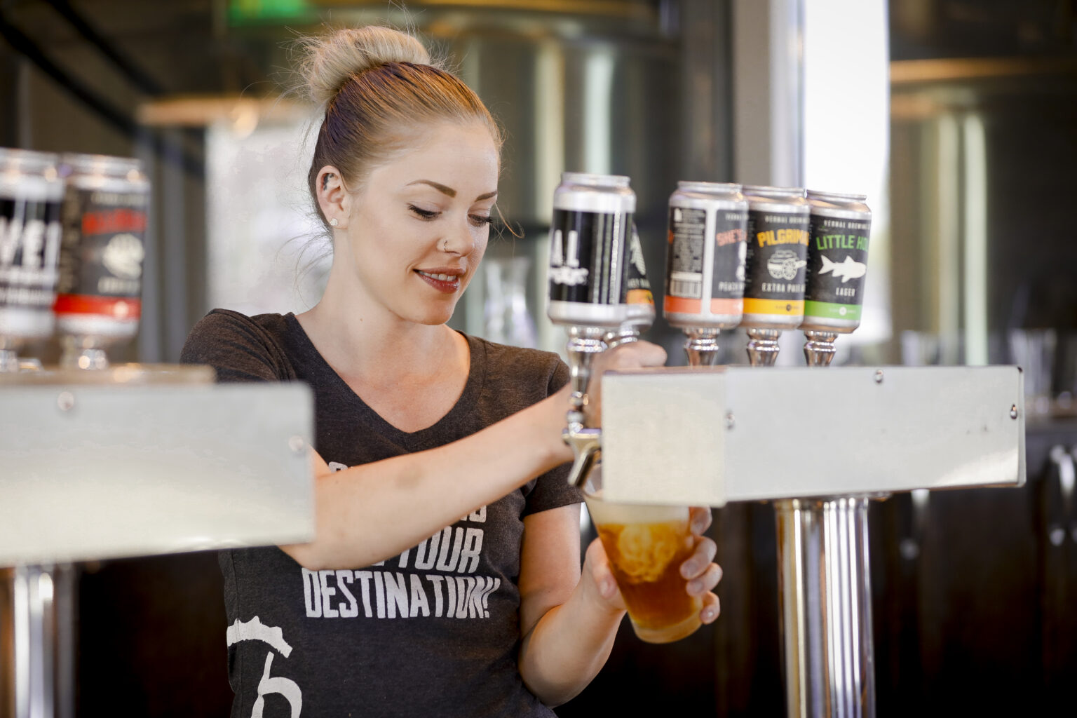 A woman pouring beer from a tap at Vernal Brewing Company