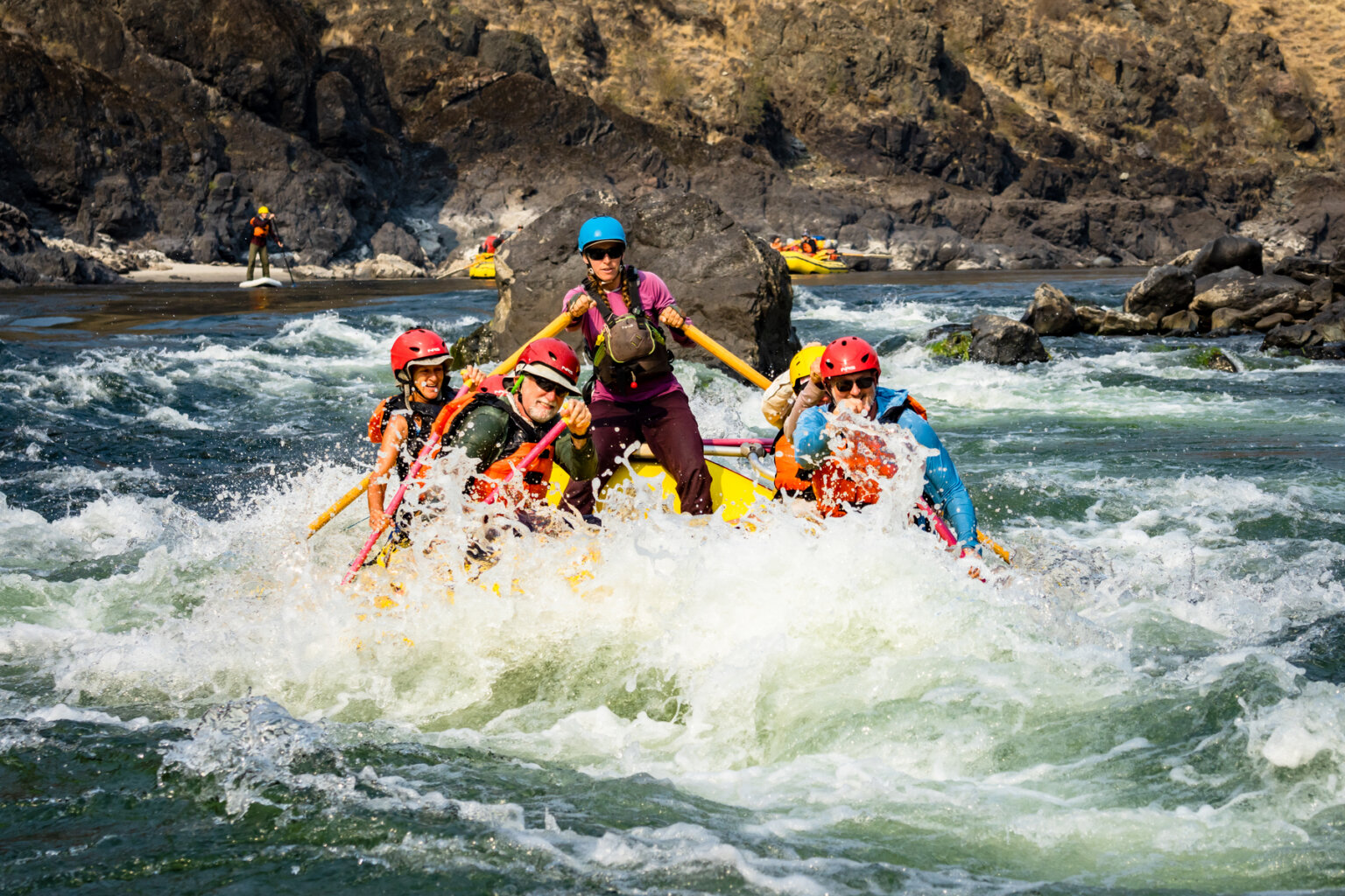 A river guides leads a paddle raft through a splashy rapid on the Lower Salmon.